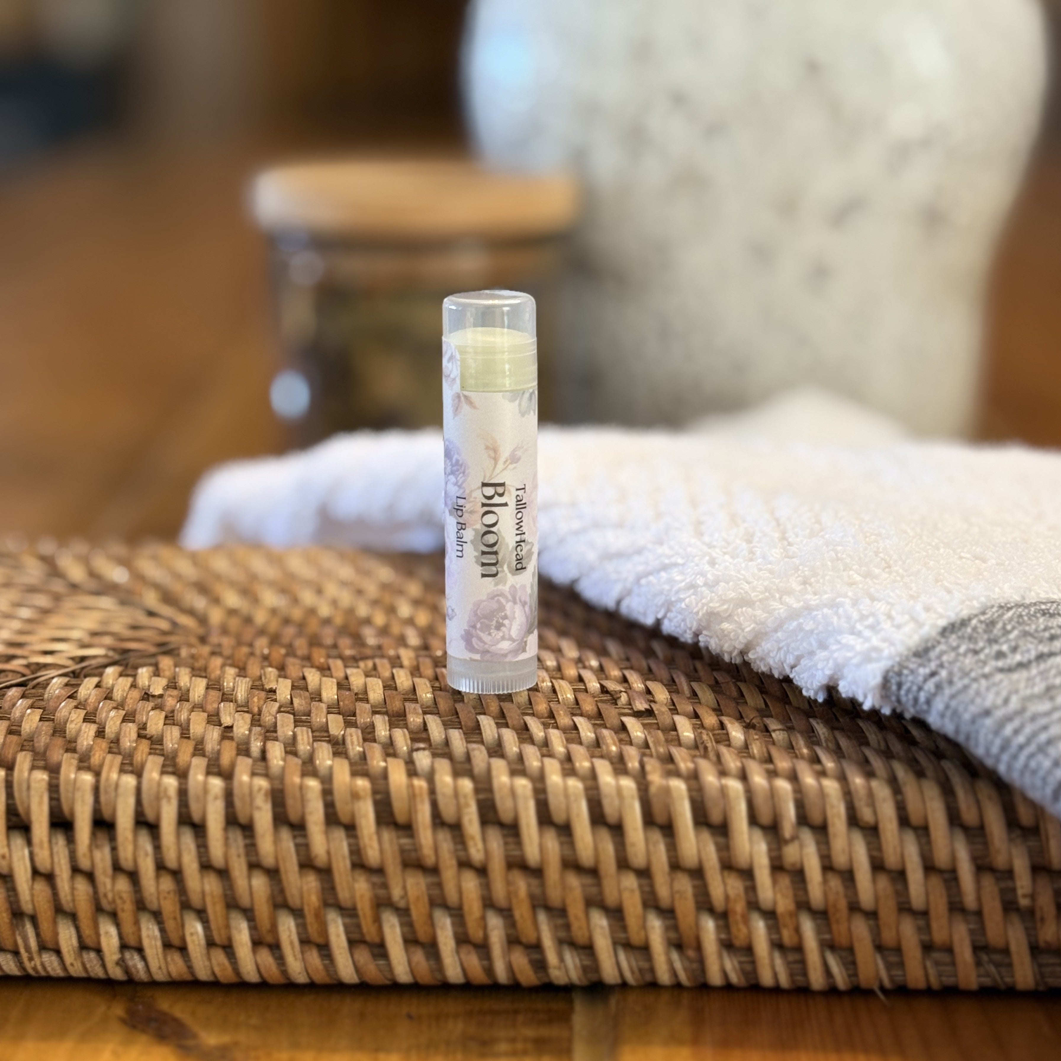 Balm tube on a woven mat with a blurred background