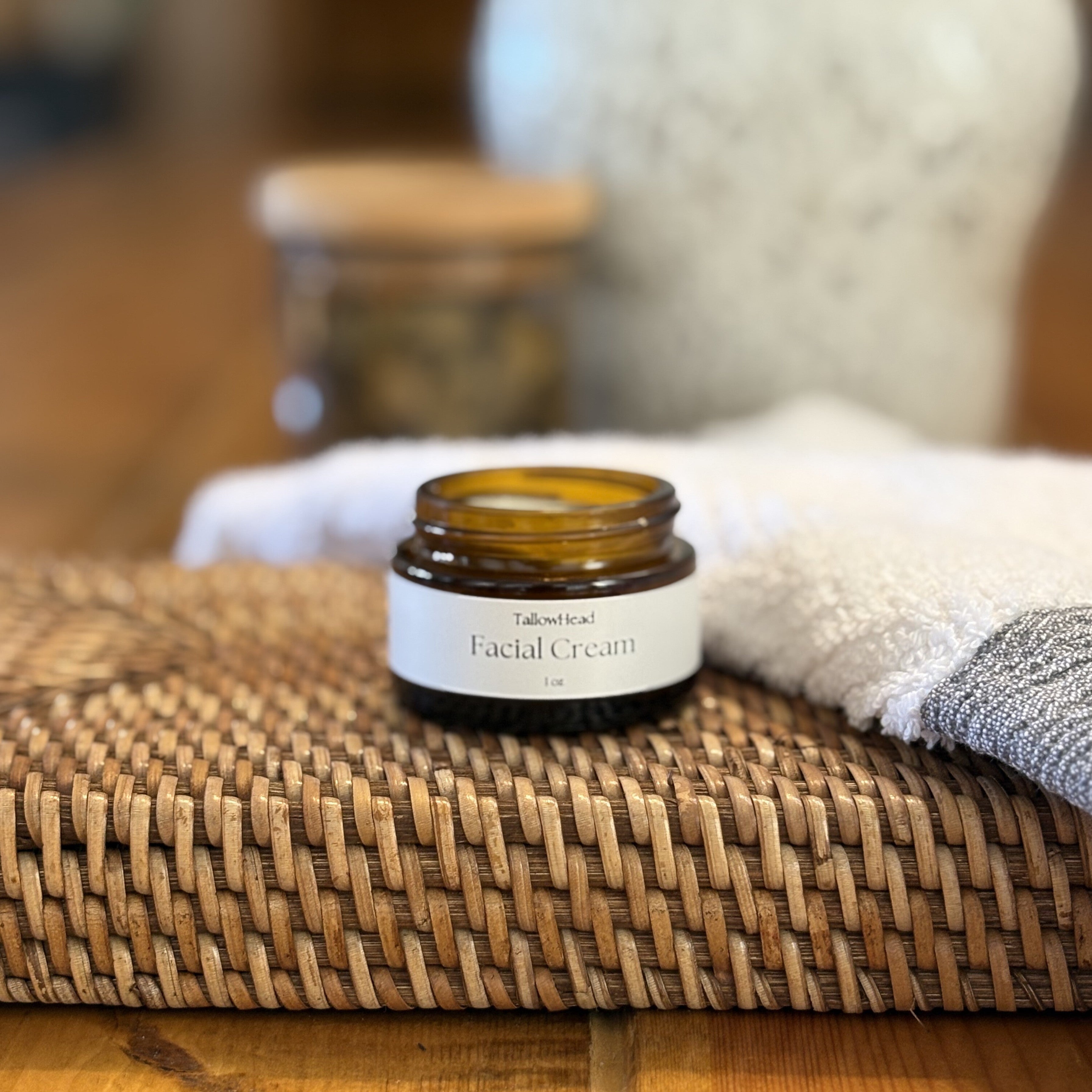 Facial cream jar on a woven mat with a blurred background