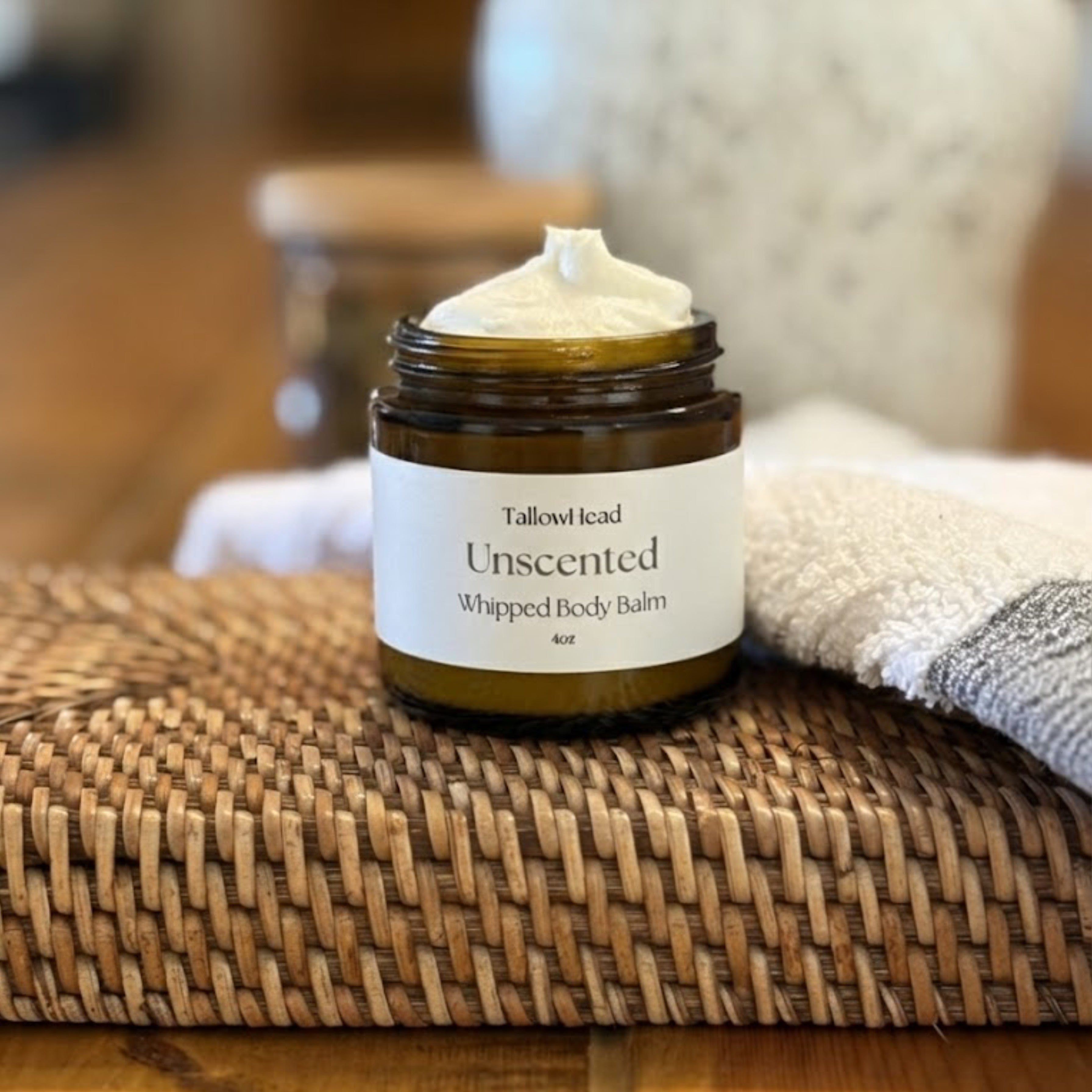 Jar of Tallowhead Unscented Whipped Body Balm on a woven mat with a blurred background