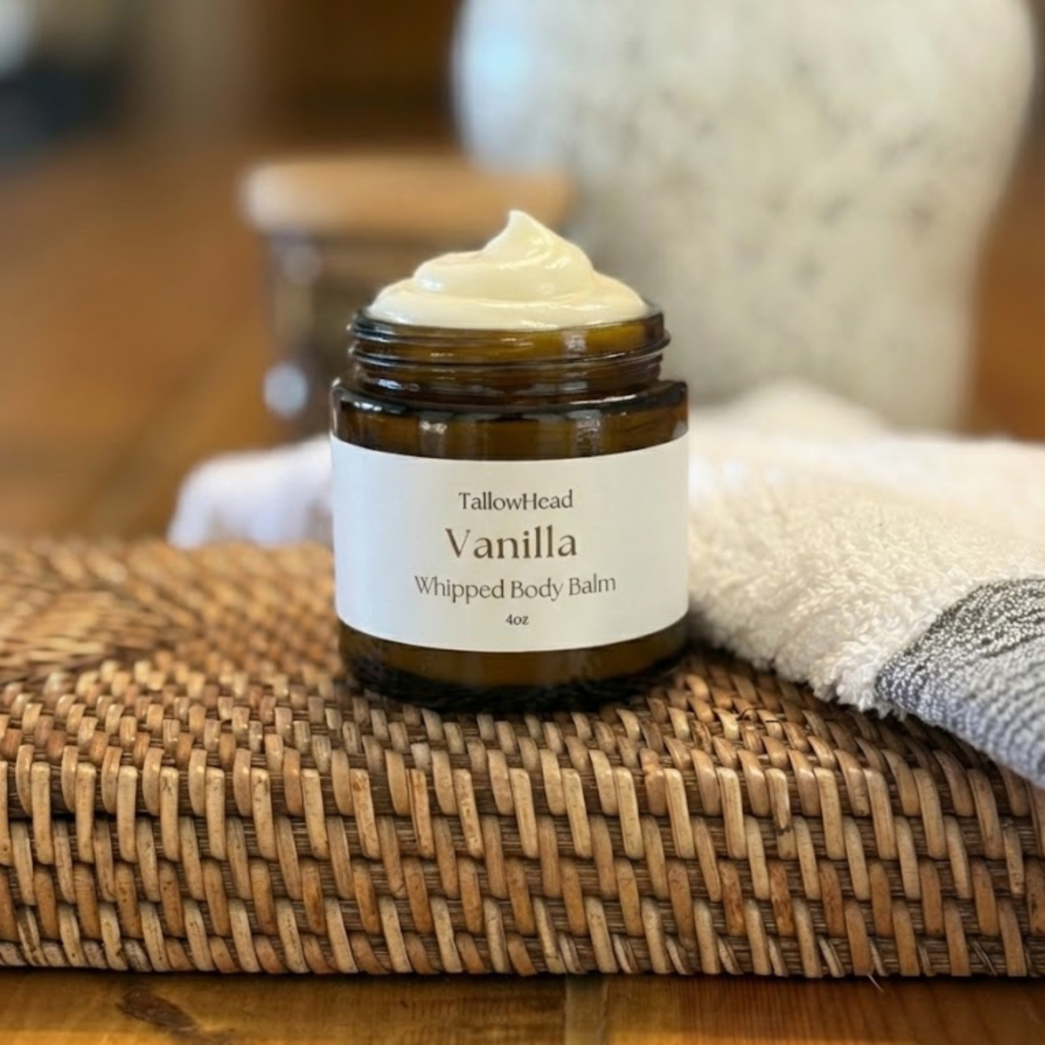 Jar of Vanilla Whipped Body Balm on a woven mat with a blurred background